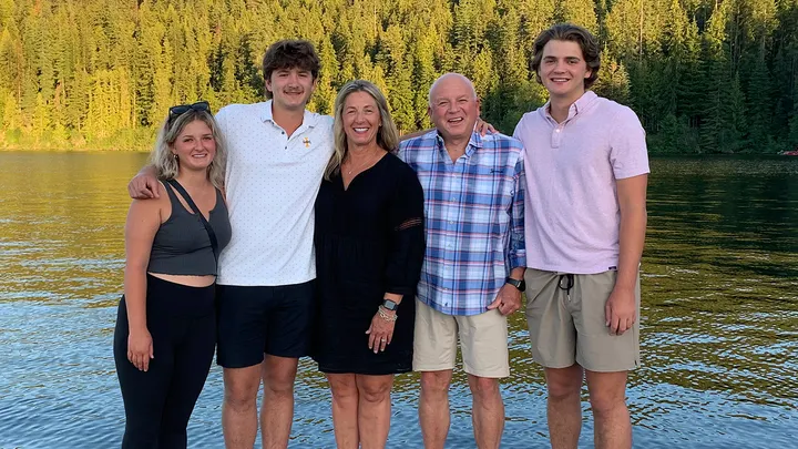 In this photo provided by Stacy Chapin, triplets Maizie, left, Ethan, second from left, and Hunter, right, pose with their parents Stacy and Jim Chapin at Priest Lake in northern Idaho in July 2022. Ethan Chapin was one of four University of Idaho students found stabbed to death in a home near the Moscow, Idaho campus on Sunday, Nov. 13, 2022. His surviving siblings both still attend the school and will turn 21 next month. (Stacy Chapin via AP)